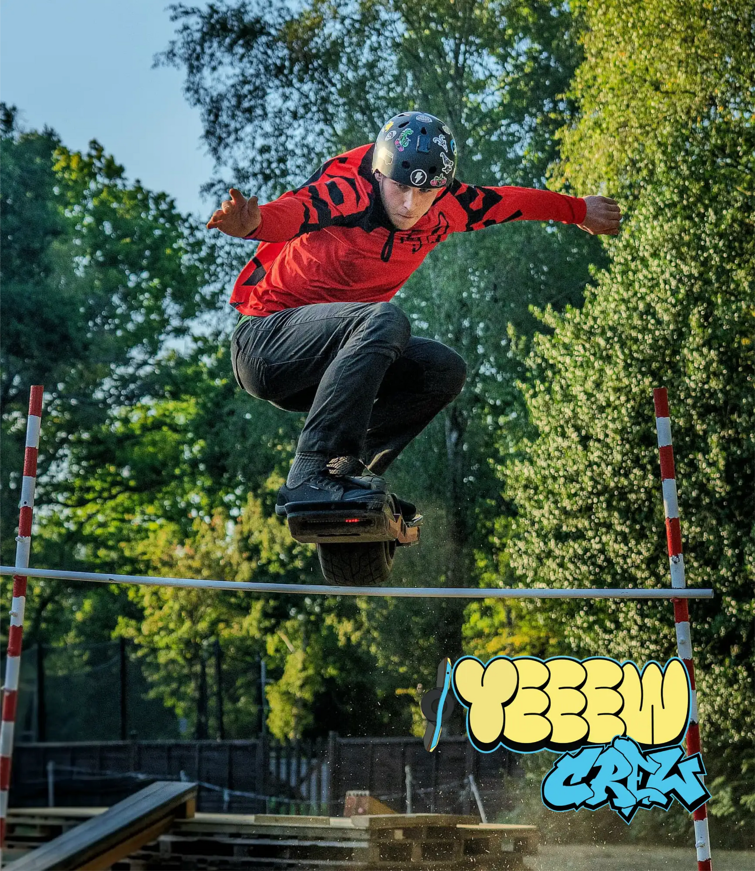Black helmet with colorful graphics and a logo on the front, worn by an individual performing a trick on a hoverboard.